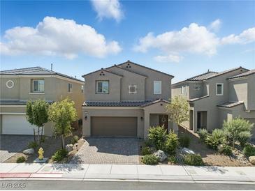 Charming two-story home featuring a brick-paved driveway and beautifully landscaped front yard at 6322 Angora Peak Ln, Las Vegas, NV 89115