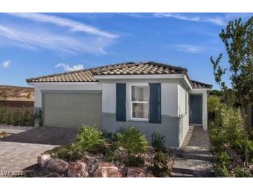 Charming single-story home with a tiled roof, gray siding, and landscaped front yard, showcasing curb appeal at 739 Wild Highlands Ln, Henderson, NV 89015