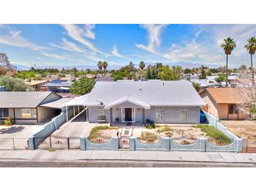 Charming single story home with desert landscaping, white paint and grey trim, palm trees, and mountain views at 1112 Sandy Cove St, Las Vegas, NV 89110