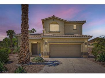 Inviting two-story home featuring a well-manicured lawn, desert landscaping, and attached two-car garage at 1701 Drifters Peak St, Las Vegas, NV 89144