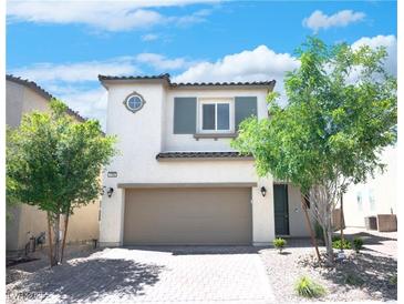 Charming two-story home with a two-car garage and well-manicured landscaping under a blue sky at 1703 Game Garden Rd, North Las Vegas, NV 89031