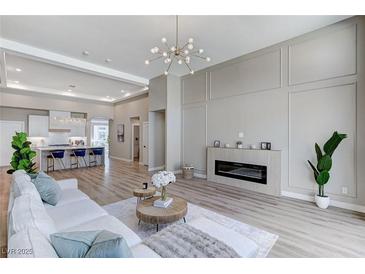 Bright living room with modern fireplace, stylish lighting, and an open floor plan to the kitchen at 2714 Langlade Ave, Henderson, NV 89052