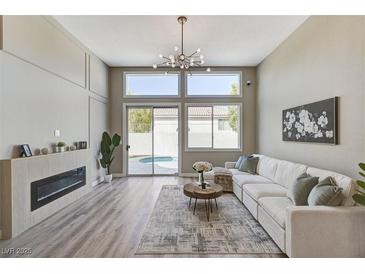 Bright living room features modern fireplace, recessed lighting, and sliding glass doors to backyard pool at 2714 Langlade Ave, Henderson, NV 89052