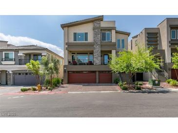 Contemporary two-story home featuring a stone facade accent, balcony, and two-car garage at 7077 Sunland Hills Ave, Las Vegas, NV 89113