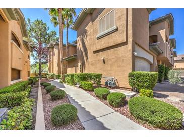 Charming townhome exterior featuring a well-maintained walkway and lush landscaping at 8737 Red Brook Dr # 204, Las Vegas, NV 89128