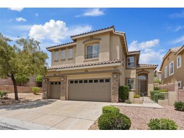 Inviting two-story home featuring a three car garage and manicured landscaping with a beautiful stone facade at 10680 Sapphire Vista Ave, Las Vegas, NV 89144
