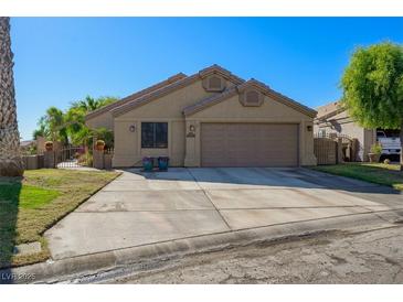 Charming single-story home with desert landscaping, a spacious driveway, and a two-car garage at 1441 Palm Dr, Laughlin, NV 89029