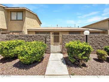 Charming front entrance featuring desert landscaping, a decorative gate, and a well-maintained walkway at 2204 Short Pine Dr, Las Vegas, NV 89108