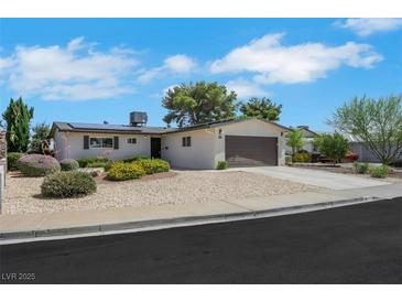 Charming single-story home with a two-car garage, well-kept landscaping, and a sunny sky at 415 Emerald Cir, Henderson, NV 89002