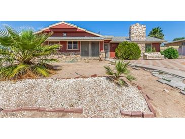 Cozy single-story home featuring desert landscaping, a stone chimney and stone facade accents at 812 Pyramid Dr, Las Vegas, NV 89107