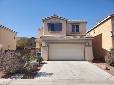 Two-story home featuring a two-car garage, desert landscaping, and a stucco exterior beneath a clear blue sky at 9120 Landons Point Ct, Las Vegas, NV 89148