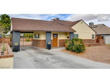 Charming single-story home featuring a gated driveway and neatly landscaped front yard at 1017 E Oakey Blvd, Las Vegas, NV 89104