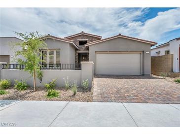 Charming single-story home with neutral stucco, stone accents, brick driveway, and two-car garage at 2194 Pigeon Hawk St, Las Vegas, NV 89138