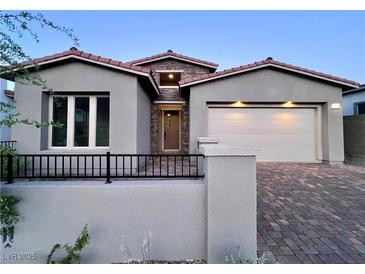 Charming single-story home with a well-manicured front yard, brick driveway, and two-car garage at 2194 Pigeon Hawk St, Las Vegas, NV 89138