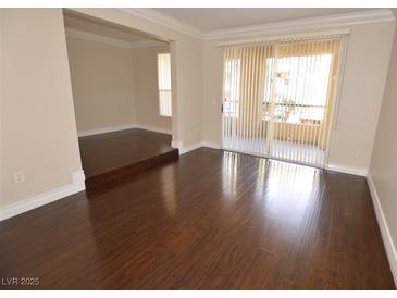 Open living room with wood floors and sliding glass doors to outdoor balcony at 270 E Flamingo Rd # 107, Las Vegas, NV 89169