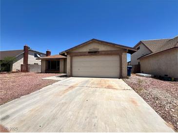Single-story home featuring a two-car garage and low maintenance landscaping at 4766 Knollwood Dr, Las Vegas, NV 89147