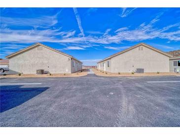 Two single-story homes, each showcasing identical exterior design with low-maintenance landscaping and ample parking space at 610 San Lorenzo St, Pahrump, NV 89048