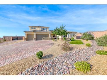 Inviting two-story home with a three car garage, desert landscaping and a brick driveway at 6311 Baker Creek St, Las Vegas, NV 89149