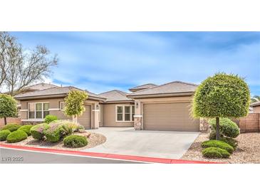Charming single-story home showcasing manicured landscaping and a spacious driveway leading to a two-car garage at 7332 Redhead Dr, North Las Vegas, NV 89084