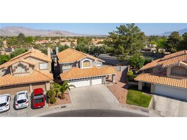 Two-story home with three-car garage, well-manicured lawn, and orange roof tiles at 8436 Kawala Dr, Las Vegas, NV 89128