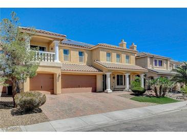 Stunning two-story home featuring an attached three-car garage and beautifully landscaped front yard with mature tree at 8448 Cambria Cellars Ct, Las Vegas, NV 89139
