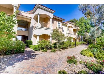Beautiful building exterior featuring balconies, classic columns, and lush landscaping on a sunny day at 12 Strada Di Circolo, Henderson, NV 89011