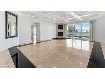 Bright living room featuring modern fireplace, floor to ceiling windows, and coffered ceilings at 2777 Paradise Rd # 303, Las Vegas, NV 89109