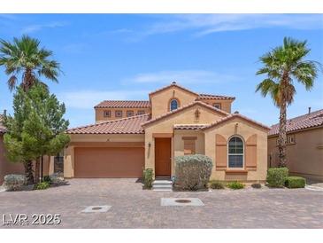 Charming stucco home with a two-car garage, tile roof, and low maintenance desert landscaping at 33 Via Di Mello, Henderson, NV 89011
