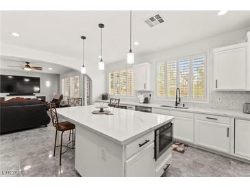 Bright kitchen features a large island with a marble countertop, stainless steel appliances, and seamless access to the living room at 366 Rancho La Costa St, Las Vegas, NV 89138