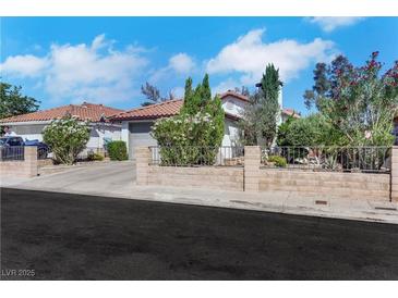 Charming single-story home featuring a tile roof, desert landscaping, and a quaint brick fence at 4629 Denwood Dr, Las Vegas, NV 89147
