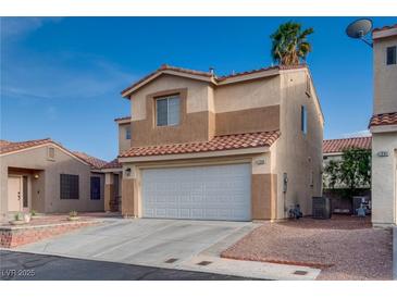 Two-story tan home featuring a white garage door and desert landscaping at 7240 Wandering Star Ct, Las Vegas, NV 89131