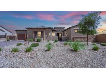 Charming single-story home featuring desert landscaping, stone accents, and a neutral color palette, captured at twilight at 7258 W Le Baron Ave, Las Vegas, NV 89178