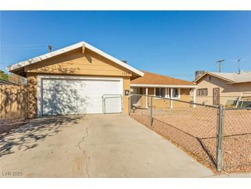 Single-story home featuring a driveway, garage and fenced yard at 1509 Lucilee St, Las Vegas, NV 89101