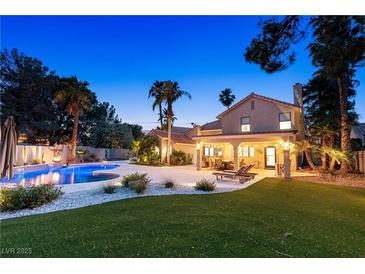 Inviting backyard pool featuring a pristine lawn and a covered patio with lounge chairs at 1990 Freeman Ct, Henderson, NV 89014