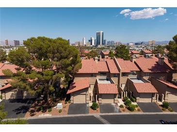 Townhomes with red tile roofs, attached garages and desert landscaping, set against the Las Vegas skyline at 3972 Tirana Way, Las Vegas, NV 89103