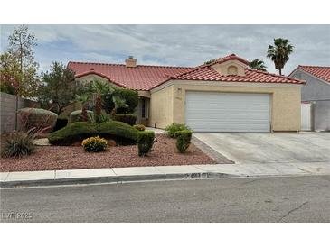 Charming single-story home with a red tile roof, neutral stucco, and well-manicured landscaping at 4013 Extenso Dr, North Las Vegas, NV 89032