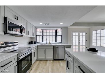 Bright kitchen featuring stainless steel appliances, modern cabinets and a view from the window above the sink at 5151 Tennis Ct, Las Vegas, NV 89120