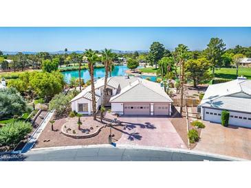 A charming one-story house features a three-car garage and lake in the background at 5401 Indian Hills Ave, Las Vegas, NV 89130