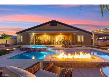 Stunning backyard pool with a spa, fire pit, and lounge chairs, perfect for outdoor entertaining at 6980 W Meranto Ave, Las Vegas, NV 89178