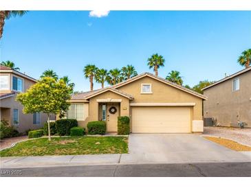 Charming single-story home featuring a well-manicured lawn, mature landscaping, and a two-car garage at 922 Lloyd George Dr, Henderson, NV 89052