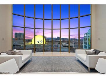 Bright living room featuring floor to ceiling windows with spectacular city views and stylish white sofas at 1 Hughes Center Dr # 1901, Las Vegas, NV 89169
