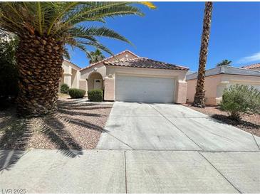 Charming single-story home featuring a two-car garage and a well-manicured front yard with mature trees at 2324 Catskill Ct, North Las Vegas, NV 89031