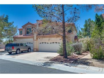 Charming two-story home with a red-tile roof, lush landscaping, and spacious driveway at 4487 Tomer Ln, Las Vegas, NV 89121