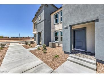 Charming townhome featuring a modern facade, neat landscaping, and a welcoming front entrance at 6188 Hibiscus Garden St # 174, North Las Vegas, NV 89081
