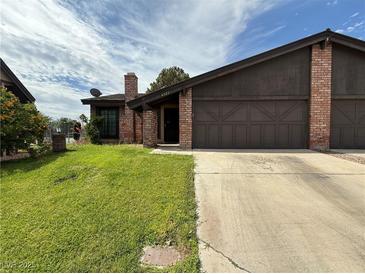 Charming single-story home with brick accents, a two-car garage, and a well-maintained lawn at 6521 Sugarpine Ln, Las Vegas, NV 89107