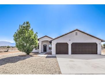 Charming single-story home featuring a two-car garage, desert landscaping, and a welcoming front entrance at 861 S Ford Loop, Pahrump, NV 89048