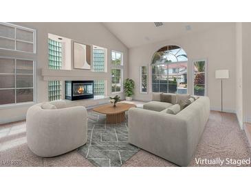 Bright living room with fireplace, vaulted ceilings, and large windows offering ample natural light at 1312 Fragrant Spruce Ave, Las Vegas, NV 89123