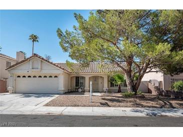 Charming single-story home with a two-car garage, desert landscaping, and mature shade tree at 1502 Cliff Branch Dr, Henderson, NV 89014