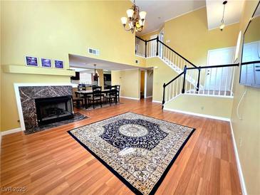Bright living room featuring a fireplace, wood floors, and staircase to the second floor at 1628 Palmae Way, Las Vegas, NV 89128