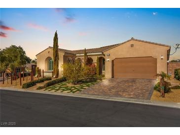 Charming single-story home with a well-manicured lawn, paver driveway, and attached two-car garage at 2 Lago Turchino Ct, Henderson, NV 89011